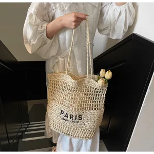 Vue détaillée du sac cabas en paille tissée avec lettres brodées et grande capacité.