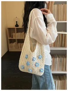 Elegante bolso de hombro tejido en crochet beige con bonitos detalles florales azules.