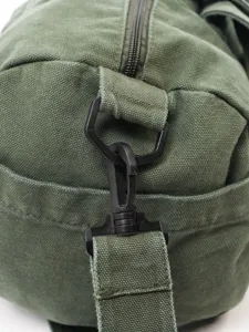Duurzame groene canvas reistas detail, zwarte hardware, schouderband clip, tas.