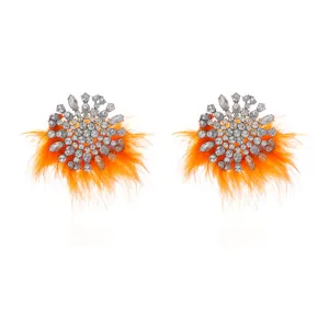Gedetailleerde close-up van sprankelende strass-kristallen gecombineerd met heldere oranje veren.