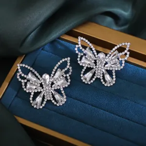 Detailed close-up of sparkling crystal butterfly earrings with rhinestone pave design.