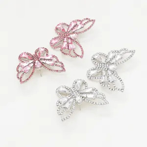 Close-up of rhinestone butterfly earrings with pink and clear crystals and claw chain.