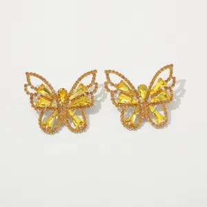 Detailed view of shiny rhinestone butterfly earrings, vintage style yellow crystal jewelry.