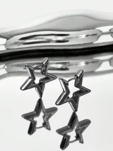 Close-up of stylish star-shaped huggie earrings in gunmetal finish with geometric cutout.