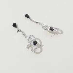 Pendientes largos de plata con lazo de cristal y piedra negra lágrima estilo retro.