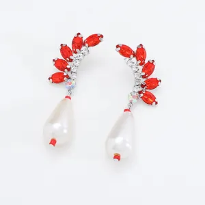 Gedetailleerd overzicht van elegante oorbellen met rode kristallen en parels voor feestjes.