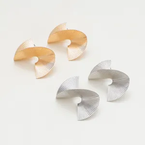 Vue détaillée des boucles d'oreilles spirale métal 3D irrégulières en or et argent.