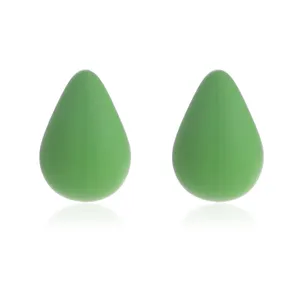 Detailopname van minimalistische groene druppelvormige matte hars oorknopjes, elegant.
