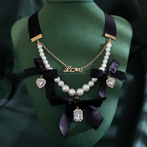 Elegant vintage pearl choker necklace with black bows and rhinestone heart pendants for women.