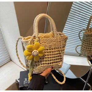 Chique geweven strooien emmertas met gele bloemenhanger en trekkoordsluiting voor zomer.