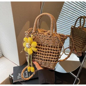 Detail van geweven strooien handtas met gele bloemhangster en katoenen voering.