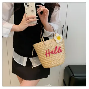 Sweet straw woven handbag for women, summer beach bag with cute Hello embroidery and flower decor.