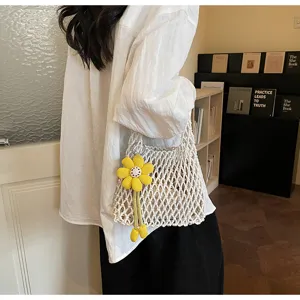 Chic white crochet mesh handbag for women with yellow flower charm, stylish summer beach tote.