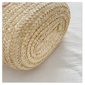 Detailed view of women's straw woven handbag texture, natural corn husk beach bag.