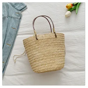Straw woven handbag with leather handles, perfect summer beach and vacation accessory.