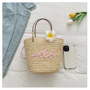 Sweet straw woven handbag with cute pink letter embroidery and floral decor for beach holiday.