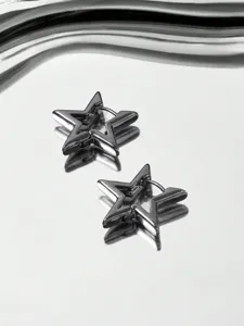 Close-up detail of minimalist star hoop earrings with hollow geometric metallic design.