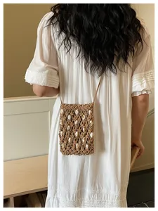 Detail shot of the bohemian woven crossbody phone bag featuring delicate shell bead decorations.