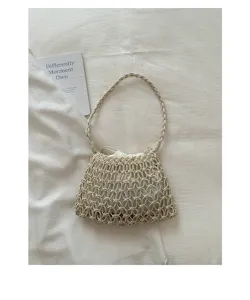 Detail shot of the bohemian woven shoulder bag, cream color straw with braided strap and pouch.