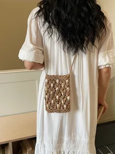 Bohemian macrame phone bag, stylish woven crossbody handbag with shell beads for beach vacation.
