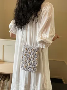 Boho hollow beaded phone bag for women, stylish woven crossbody bag for beach vacation.