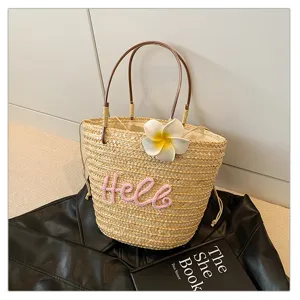 Sweet straw woven handbag with floral decor and Hello embroidery, stylish seaside beach bag.