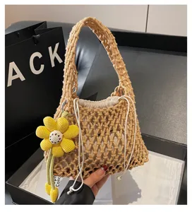 Close-up detail of the beige crochet woven net handbag with cute yellow flower charm accessory.