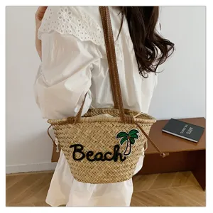 Sac de plage en paille d'ete avec laniere en cuir, grand sac cabas epaule pour vacances.