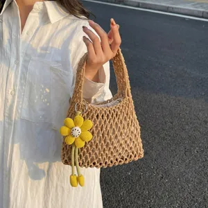 Detailed view of the woven net handbag with floral charm, perfect for daily casual styling.