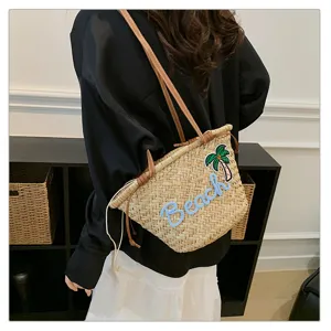 Vue détaillée du sac bandoulière en paille tissée, style vacances à la plage brodé.