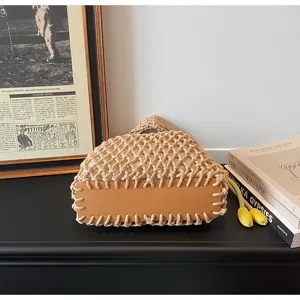 Detailed view of the woven net handbag showing delicate cotton knotting and brown leather base.
