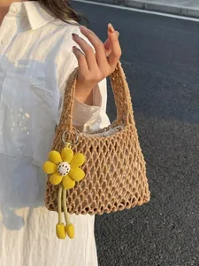 Casual hollow-out woven handbag for women featuring an inner lining and cute yellow flower pendant.
