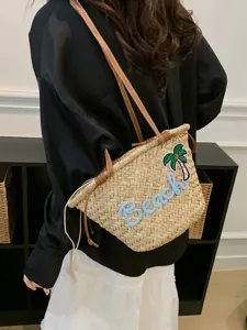 Sac à bandoulière en paille tissée avec broderie de plage et lanières en cuir marron.