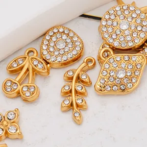 Gros plan de pendentifs dorés en strass aux formes mignonnes variées pour la création de bijoux.