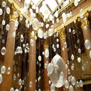 Transparent balloons hanging in a luxurious hall scene, perfect for wedding decoration details.