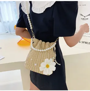 Chic straw bucket bag with pearl chain and daisy flower, stylish resort beach crossbody bag.
