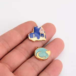 Close-up of DIY stainless steel enamel heart and moon charms for handmade jewelry making.