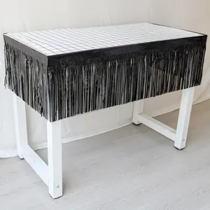 Detailed view of the black fringe curtain table skirt with grid pattern for party decor.
