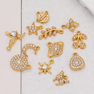 Gros plan de charms dorés assortis sertis de strass avec étoiles, lunes et jolis papillons brillants.