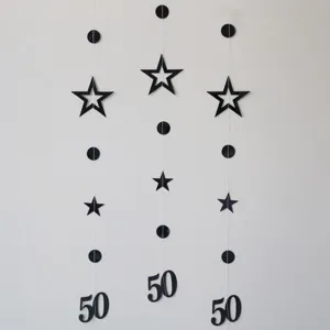 Black paper garland detail featuring hollow stars, circles, and number 50 for party decor.