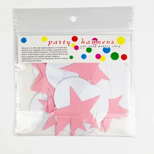 Detail view of pink paper star and white circle garland string for party hanging decor.
