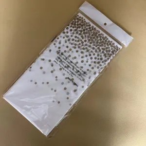 Gevouwen wegwerp tafelkleed van gouden en zilveren stippen plastic in detail verpakking
