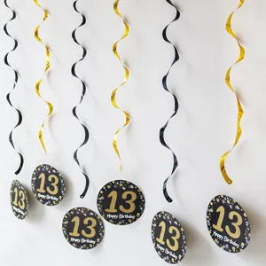 Close up detail of black and gold 13th birthday party hanging swirl decorations and tags.