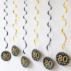 Close-up of black and gold 80th birthday party hanging swirls and card decorations.