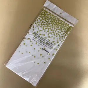 Gedetailleerd weergave van wegwerp tafelkleed met gouden stippenpatroon en verpakking.