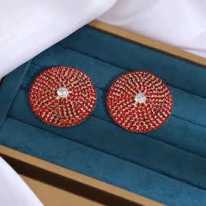 Gedetailleerde close-up van elegante rode strass oorknopjes glinsterend in een fluwelen doos.