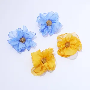 Closeup of handmade chiffon fabric flower earrings detail view, elegant floral fashion design.