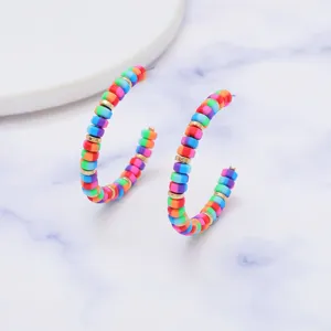 Detailfoto van kleurrijke polymeerklei kralen oorbellen met levendige meerkleurige kralen.