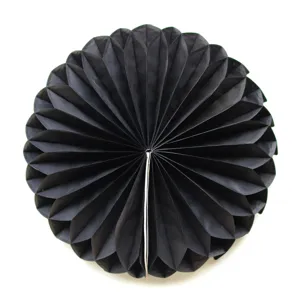 Close-up detail of the black paper honeycomb ball decoration, showing neat folds and texture.