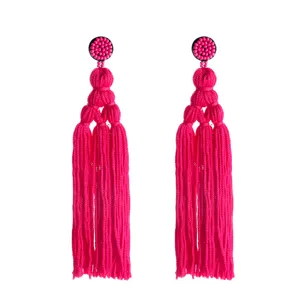 Roze kralen oorknop en gelaagde kwast oorbellen detail, handgemaakte boho stijl sieraden.